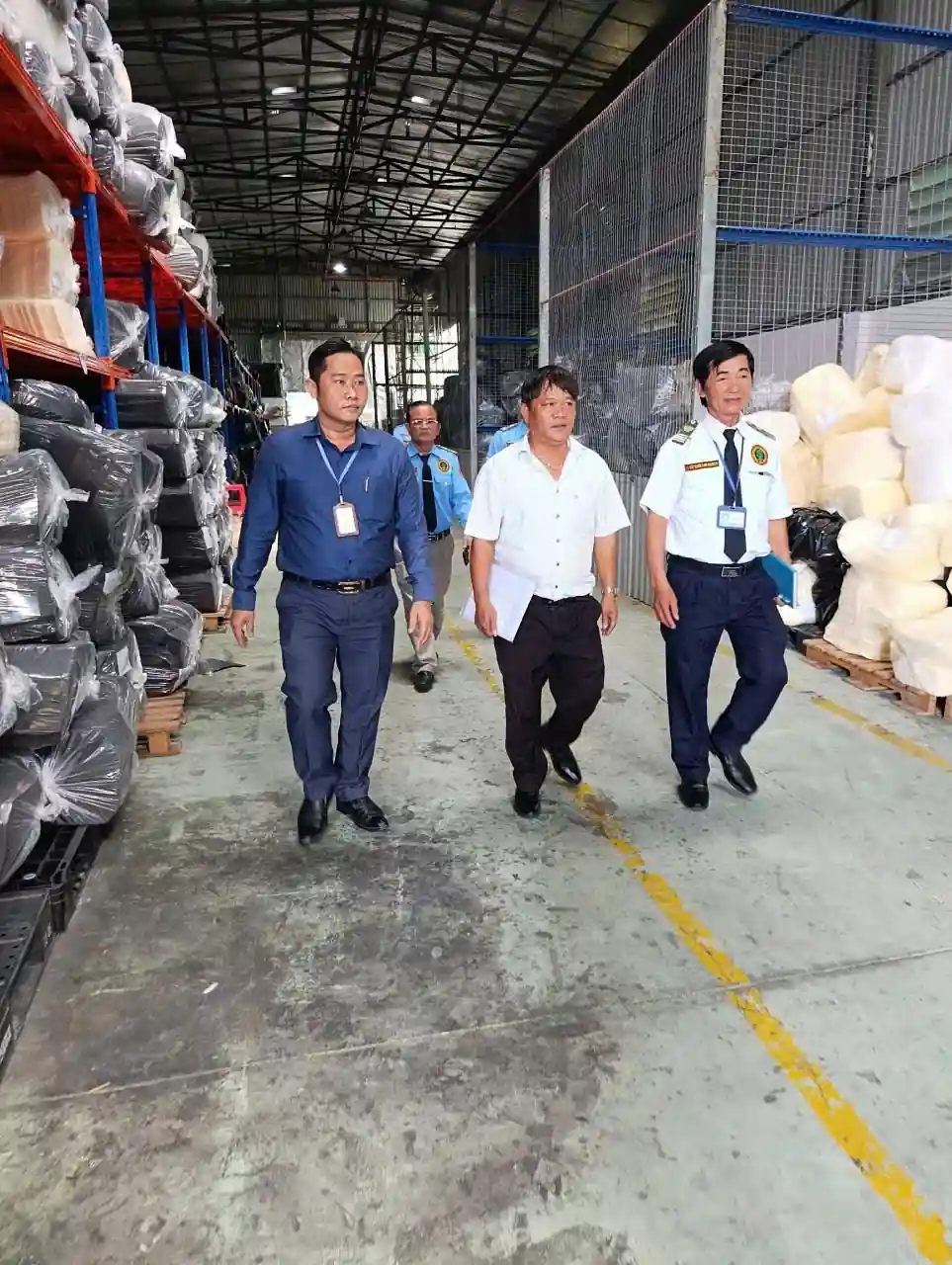 Nhân viên bảo vệ cùng đại diện doanh nghiệp đi kiểm tra khu vực kho xưởng
